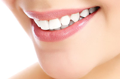 The image features a close-up of a person s smiling face with a focus on their teeth, showcasing the results of dental work or cosmetic enhancement.