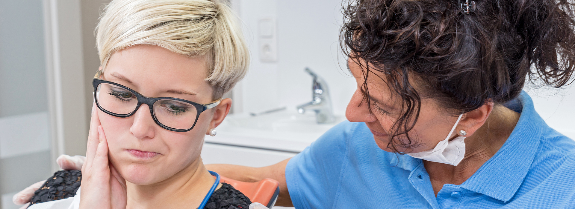 A woman receiving dental care from a professional in a dental office.