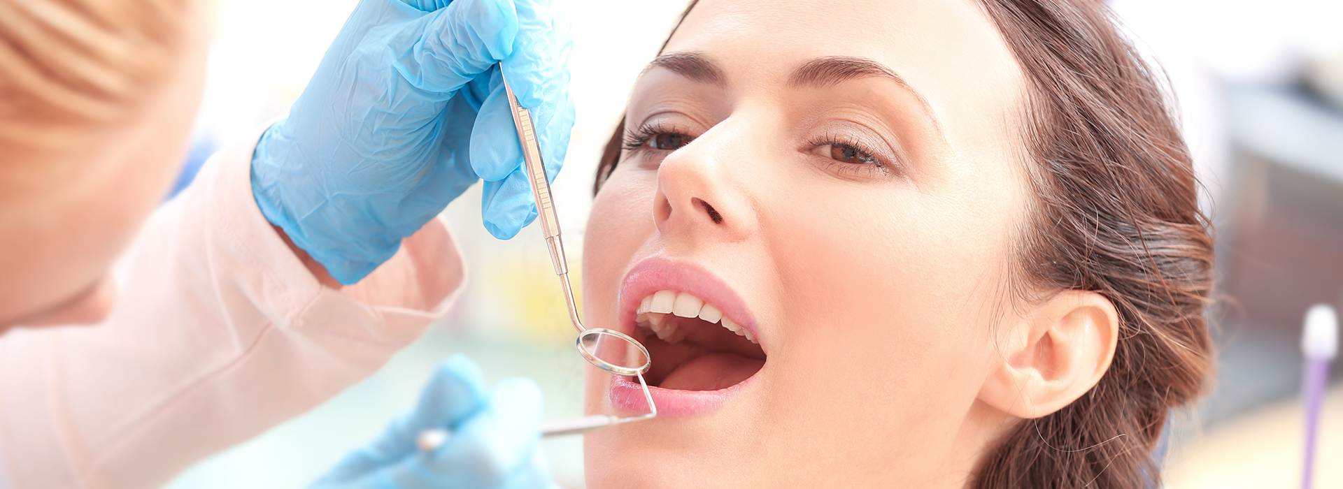 A dental hygienist performing a teeth cleaning procedure on a patient.